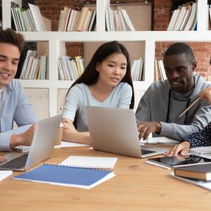 Photo of diverse graduate students around the table having discussions