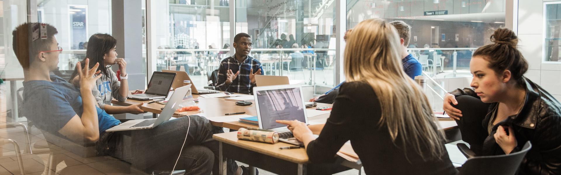 Photo of UBC students discussing with each other at a table